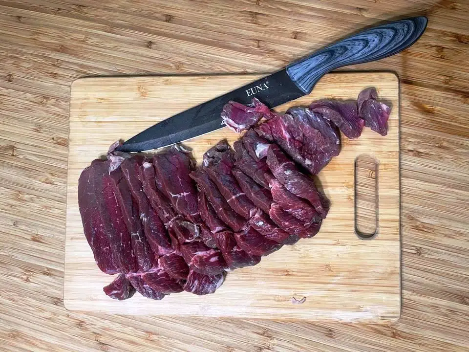 MEAT SLICED ON CUTTING BOARD