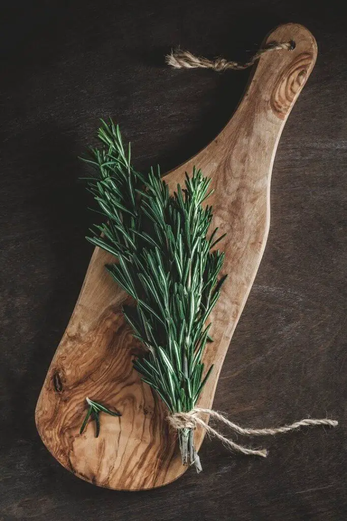 Branch of Fresh Rosemary on Cutting Board