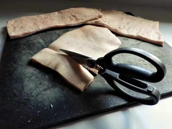 Cutting The Pork Skins And Fat With Scissors