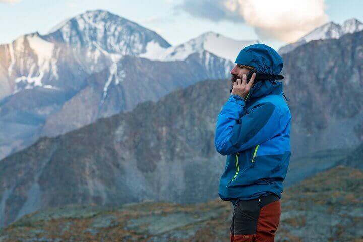 Man On Satellite Phone In Mountains