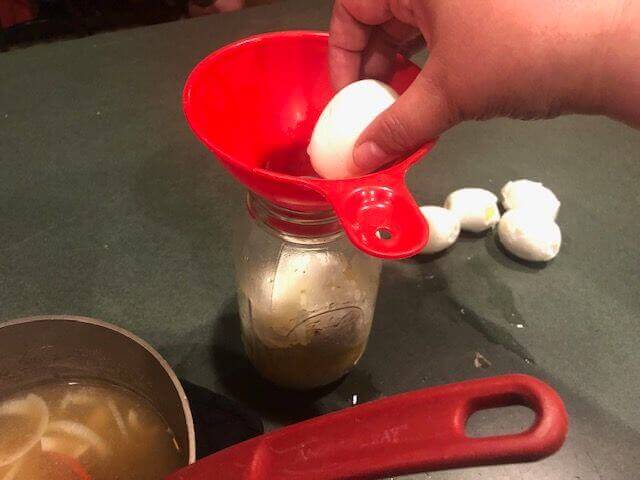 Placing Hardboiled Egg Into Jar